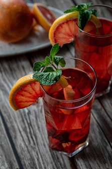 orange juice in clear drinking glass with sliced orange fruit