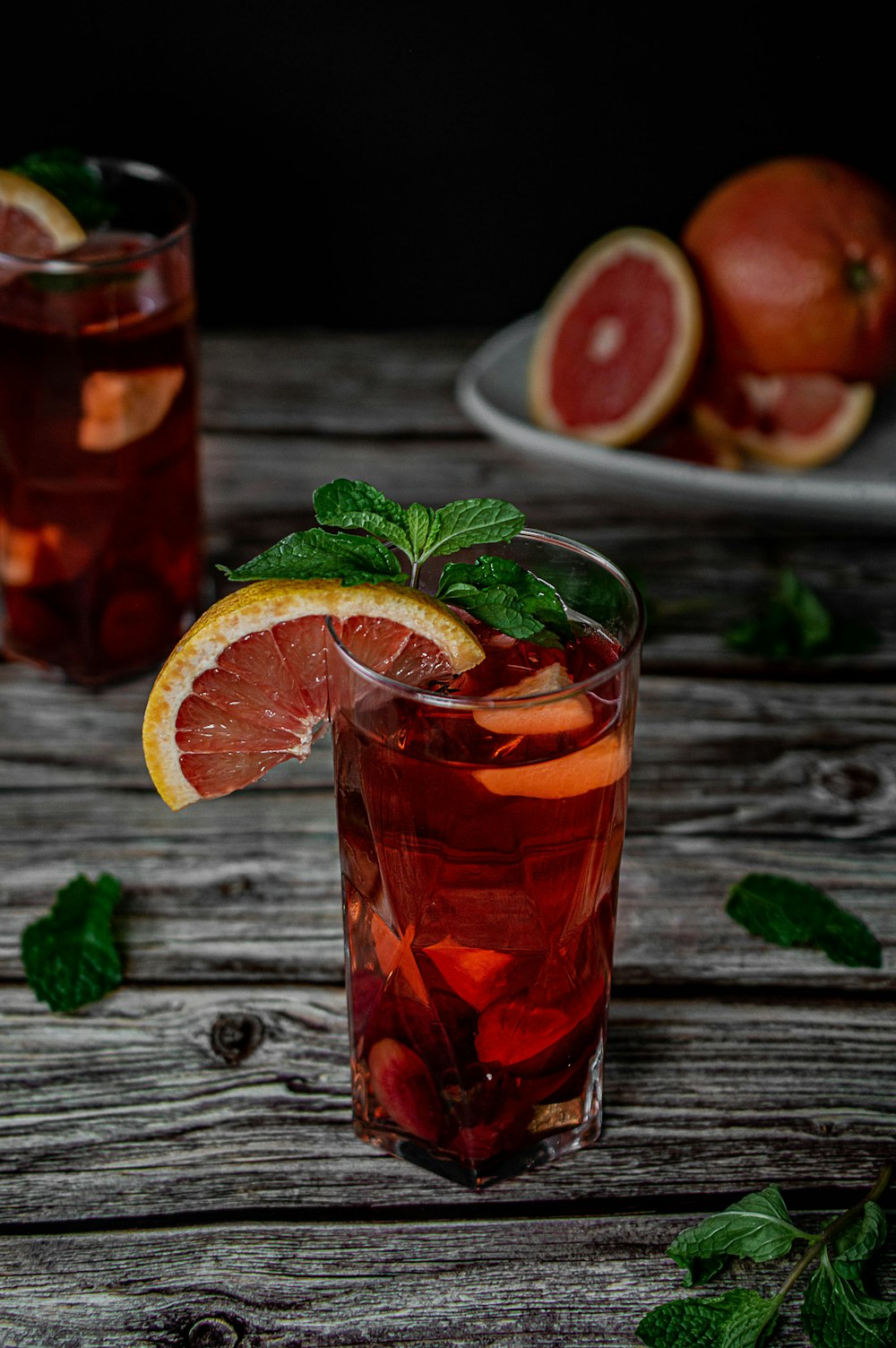 clear drinking glass with red liquid and sliced lemon