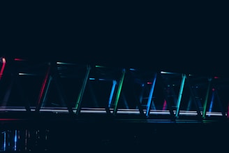 A vibrant digital illustration of a bridge made of glowing AI circuits connecting two cliffs.