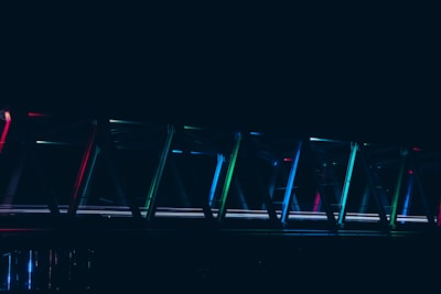 A vibrant digital illustration of a bridge made of glowing AI circuits connecting two cliffs.