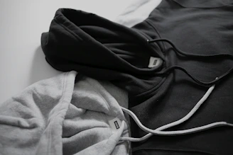 Close-up of a black and white vergesti hoodie with sleek logo embroidery on a white background