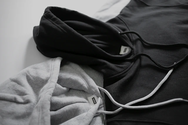 Prendas de algodón dobladas en tonos negro y gris, con sus cordones a la vista