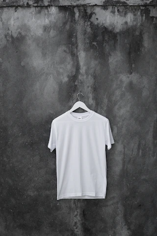 A cozy and stylish acid wash drop shoulder t-shirt hanging on a wooden hanger against a clean white background.