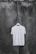 A vibrant screen-printed t-shirt hanging on a rustic wooden wall.