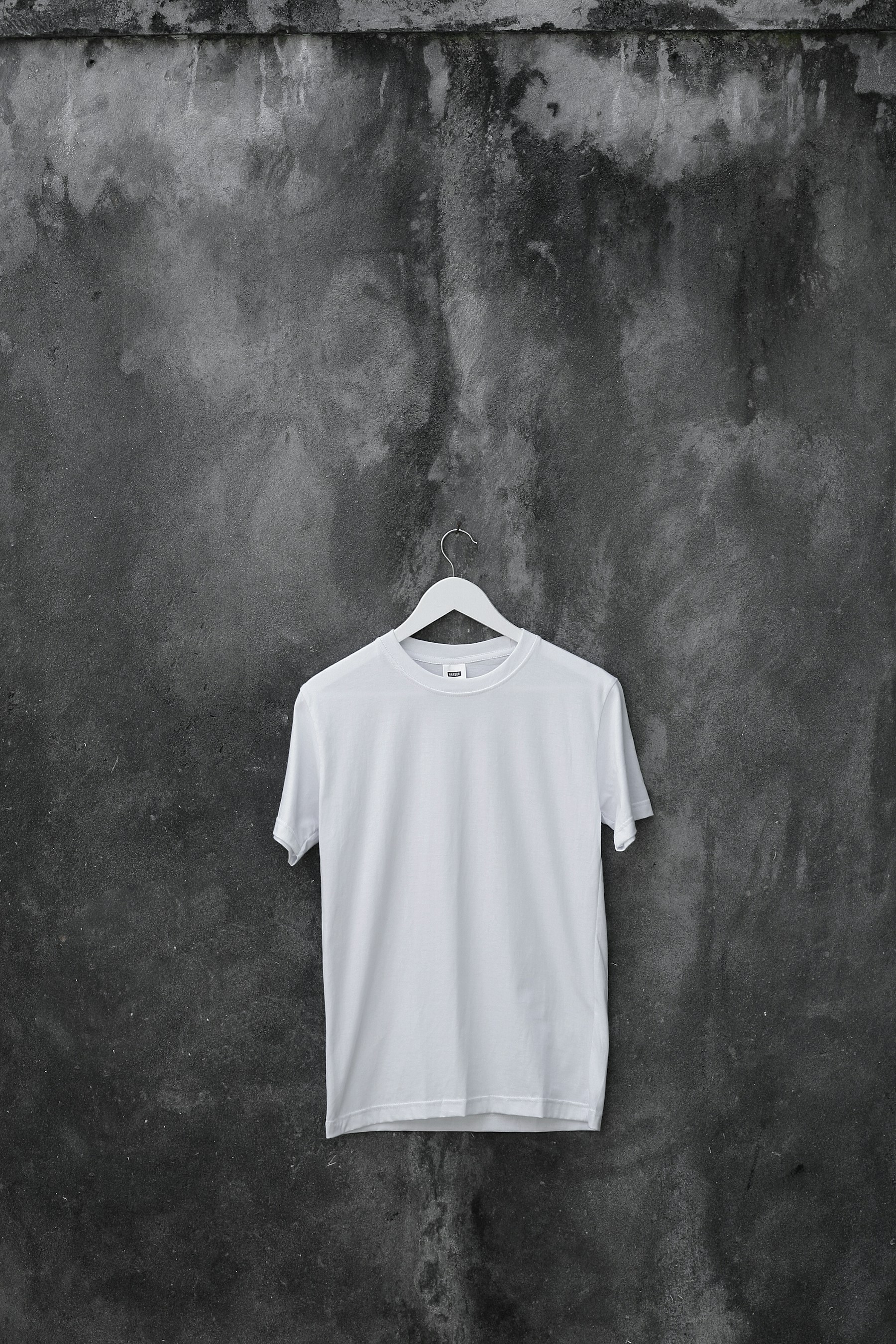 Heavyweight tee, mid-tone bone, on weathered concrete