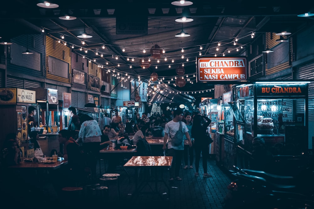 people sitting on chair near store during night time