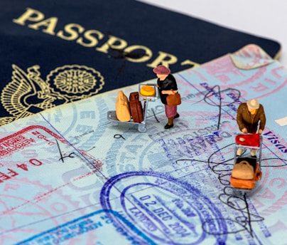 Close-up of hands organizing travel documents and passports with a blue and white background.