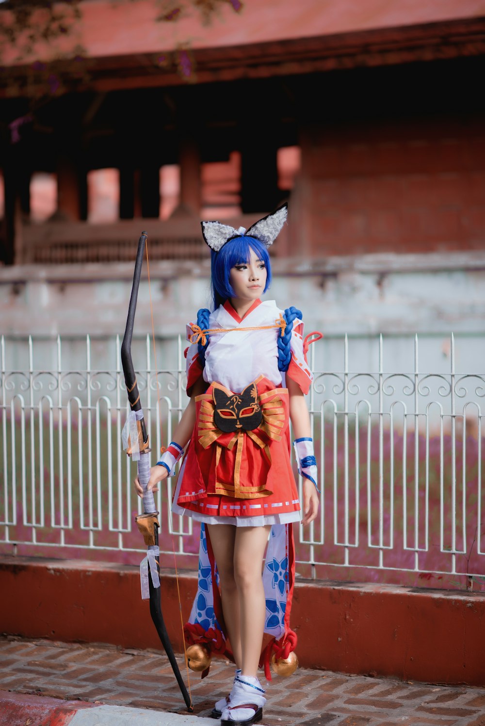 woman in red and blue dress wearing blue hat standing on brown concrete floor during daytime