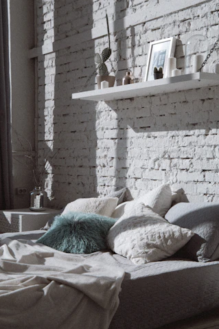 Cozy bedroom setting featuring soft, patterned bed linens and cushions.