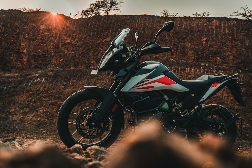 black and red sports bike on brown field during daytime