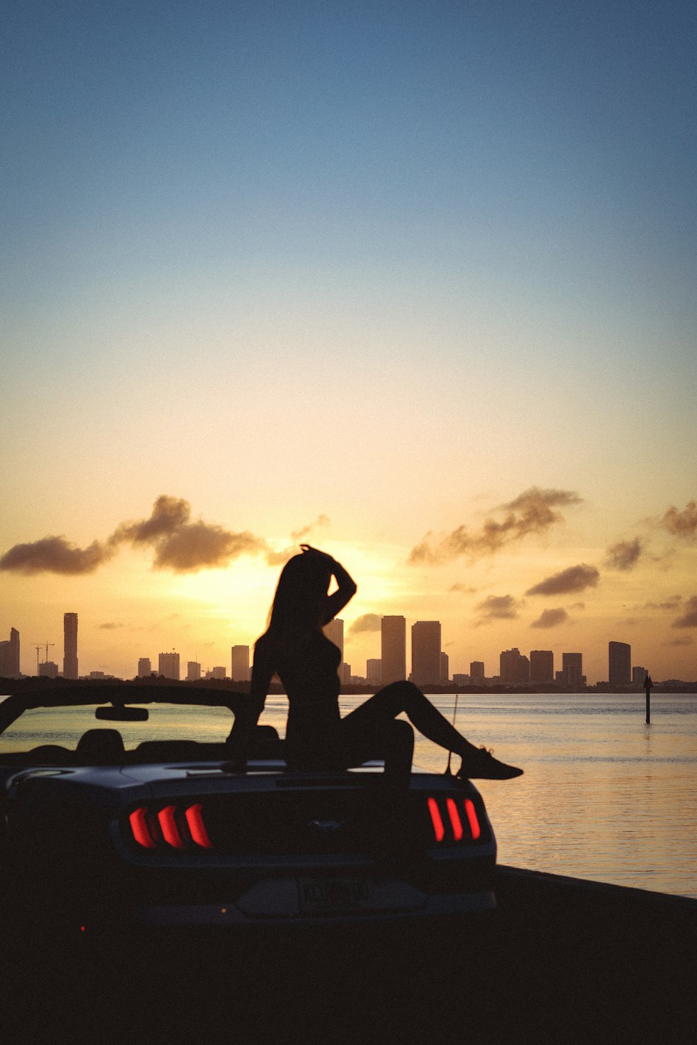 silhouette of person riding on red and black personal watercraft during sunset