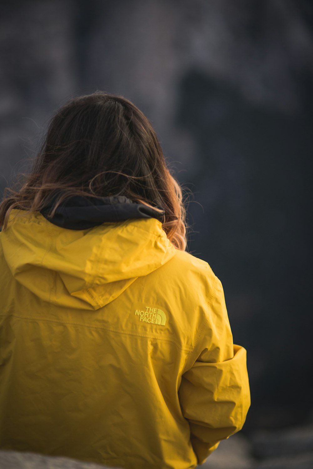 woman in yellow jacket looking at the sky