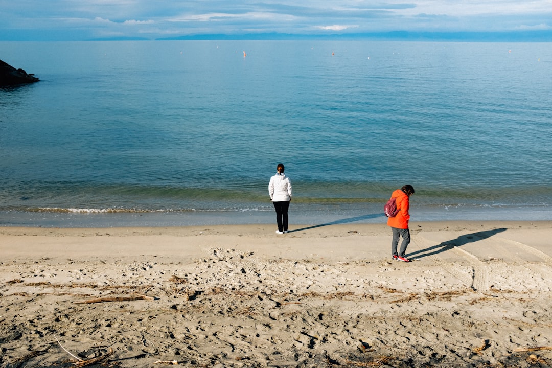 man and woman standing on beach during daytime