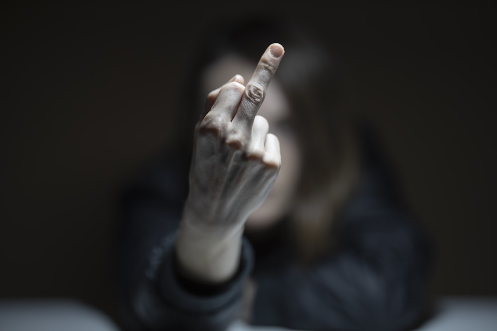 person in black long sleeve shirt holding cigarette stick