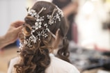 woman in white shirt with brown and white floral hair tie
