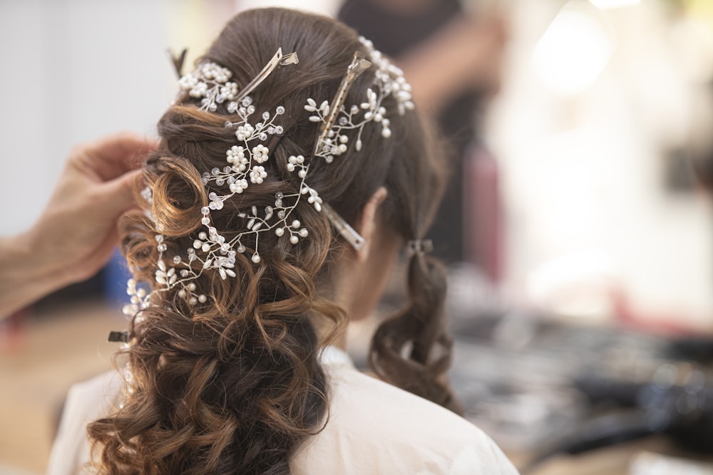 woman in white shirt with brown and white floral hair tie