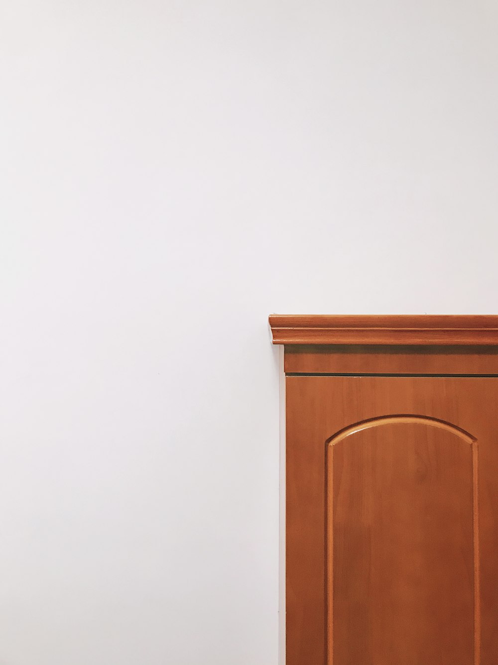 brown wooden cabinet beside white wall