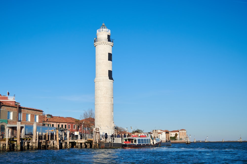 white concrete tower near body of water during daytime