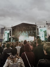 Wide shot of a massive outdoor concert stage being assembled with lights and sound equipment.