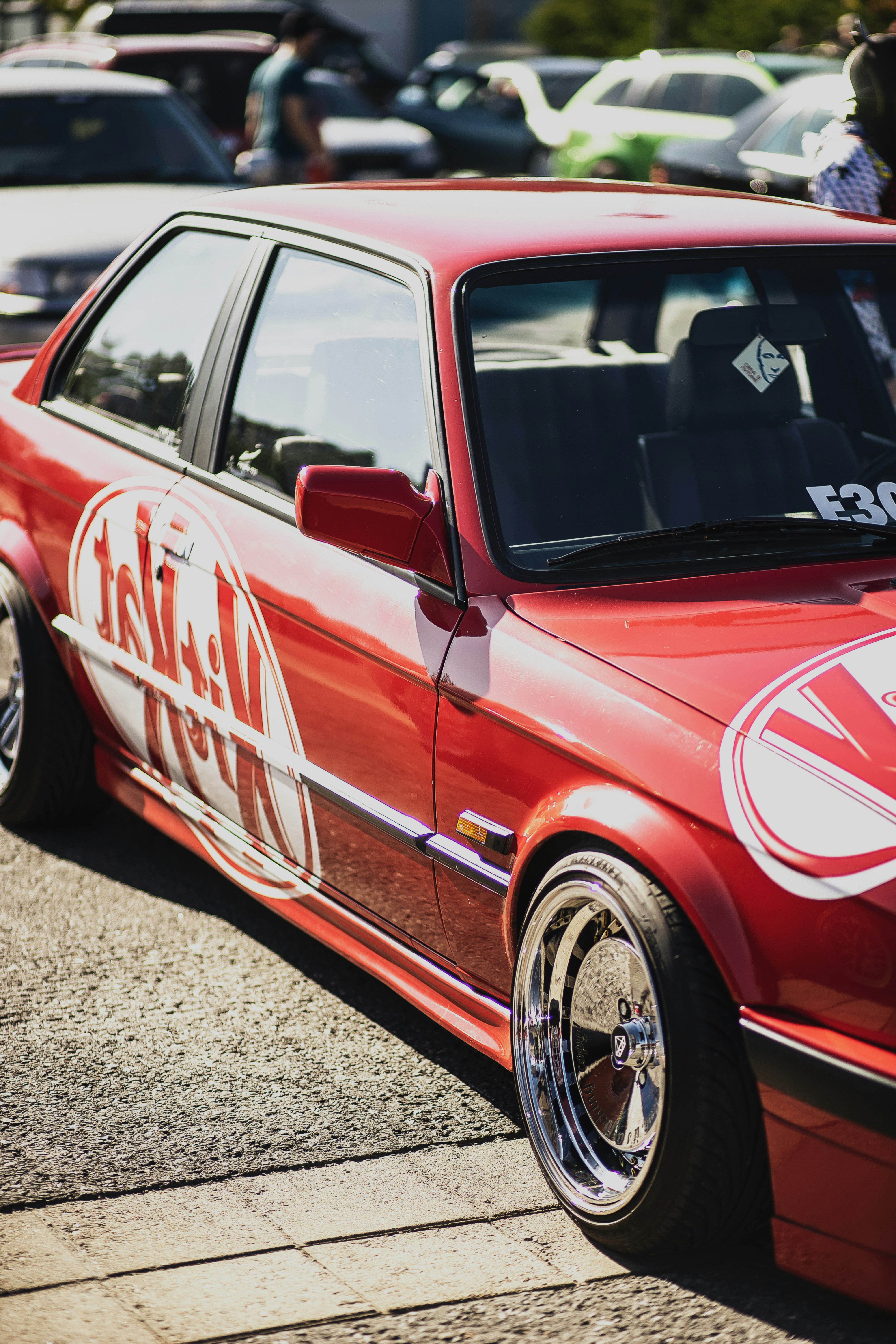 rot-weiße Limousine tagsüber auf grauer Asphaltstraße