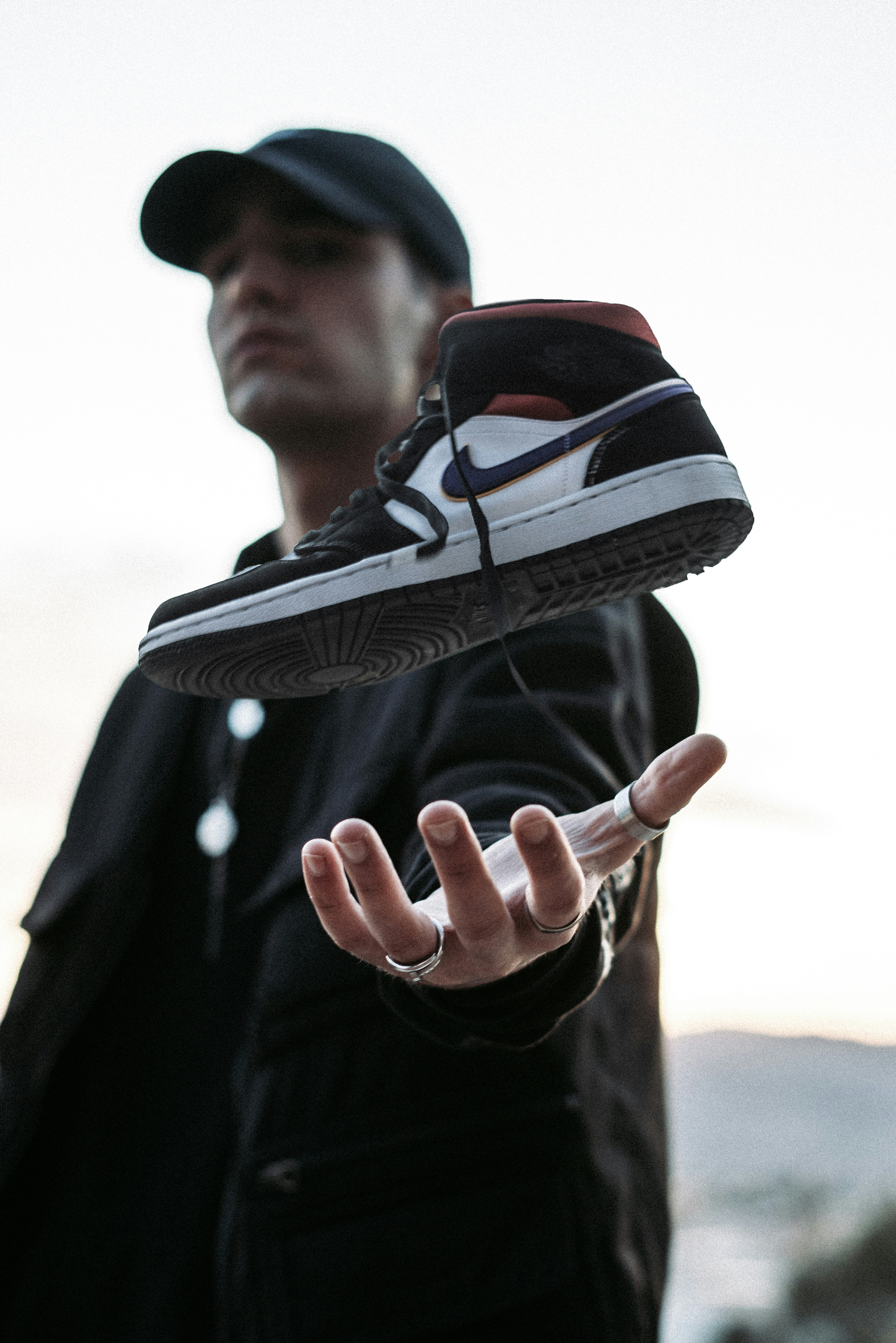 Man in black jacket holding black nike shoe - Free Photo on Unsplash