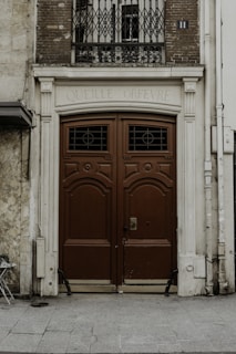 red wooden door on white concrete building