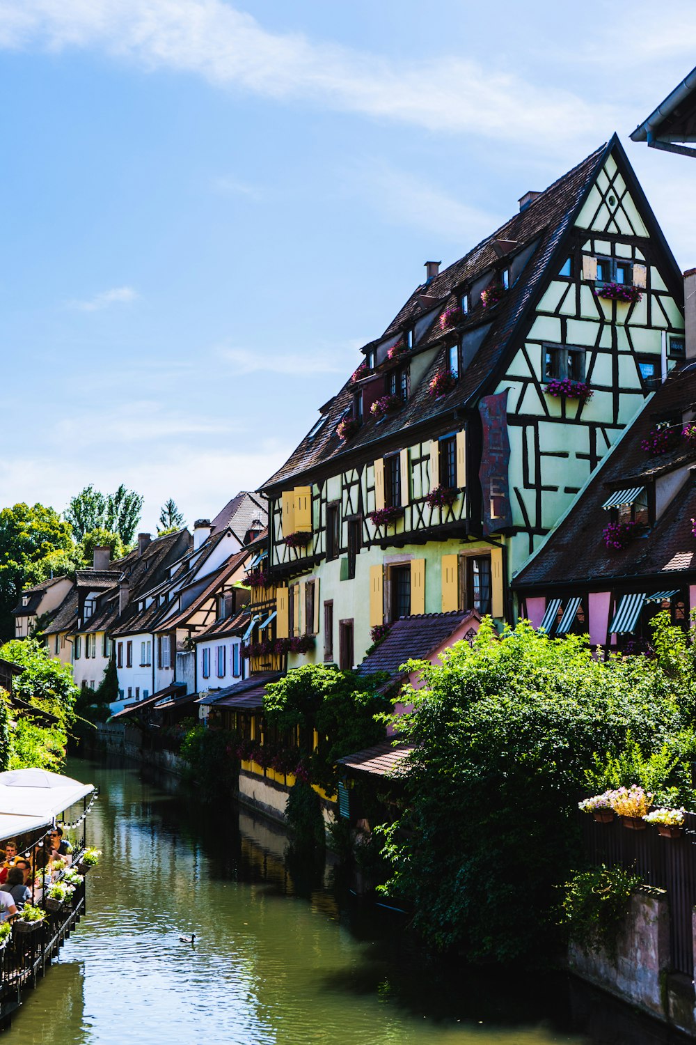 bâtiment en béton vert et brun près des arbres verts sous le ciel bleu pendant la journée