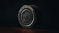 A golden compass resting on a black leather travel journal, symbolizing guidance and adventure.