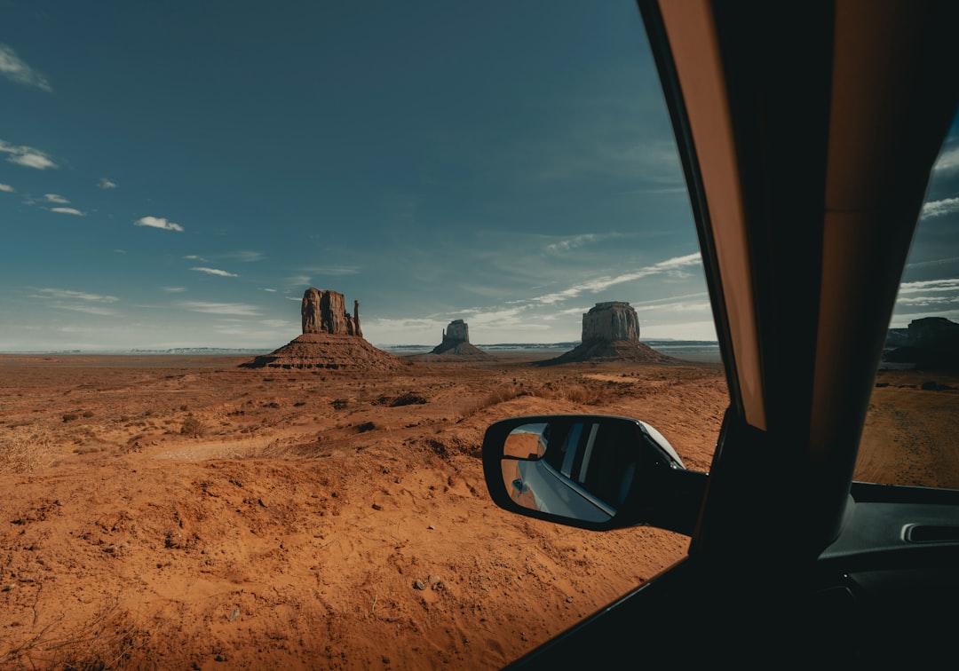 black car on brown sand under blue sky during daytime