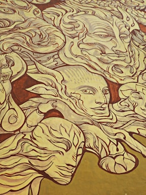A large mural featuring intricately drawn faces and abstract forms. The art style is highly detailed with numerous swirling lines and patterns that merge and diverge. The expressions on the faces vary, conveying a sense of mystery and depth.