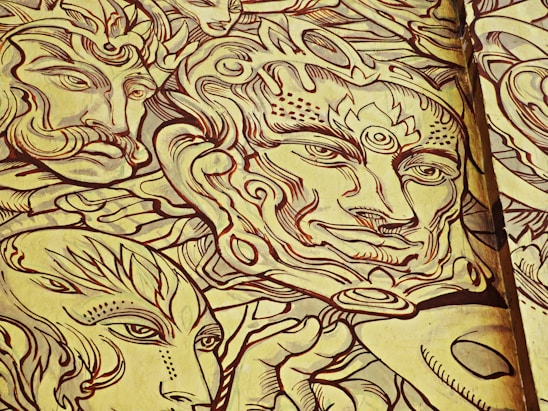 Intricate line art featuring abstract faces and patterns with ornate detailing. The design consists of multiple faces with stylized features, including exaggerated eyes and swirling patterns surrounding them. The use of bold lines and limited colors creates a unified and artistic composition.
