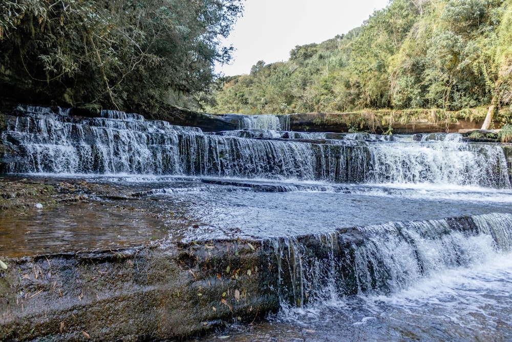 a small waterfall with water cascading over it