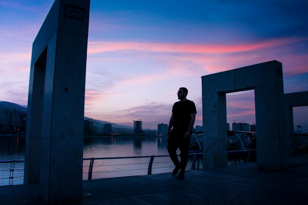 man in black jacket standing on dock during daytime