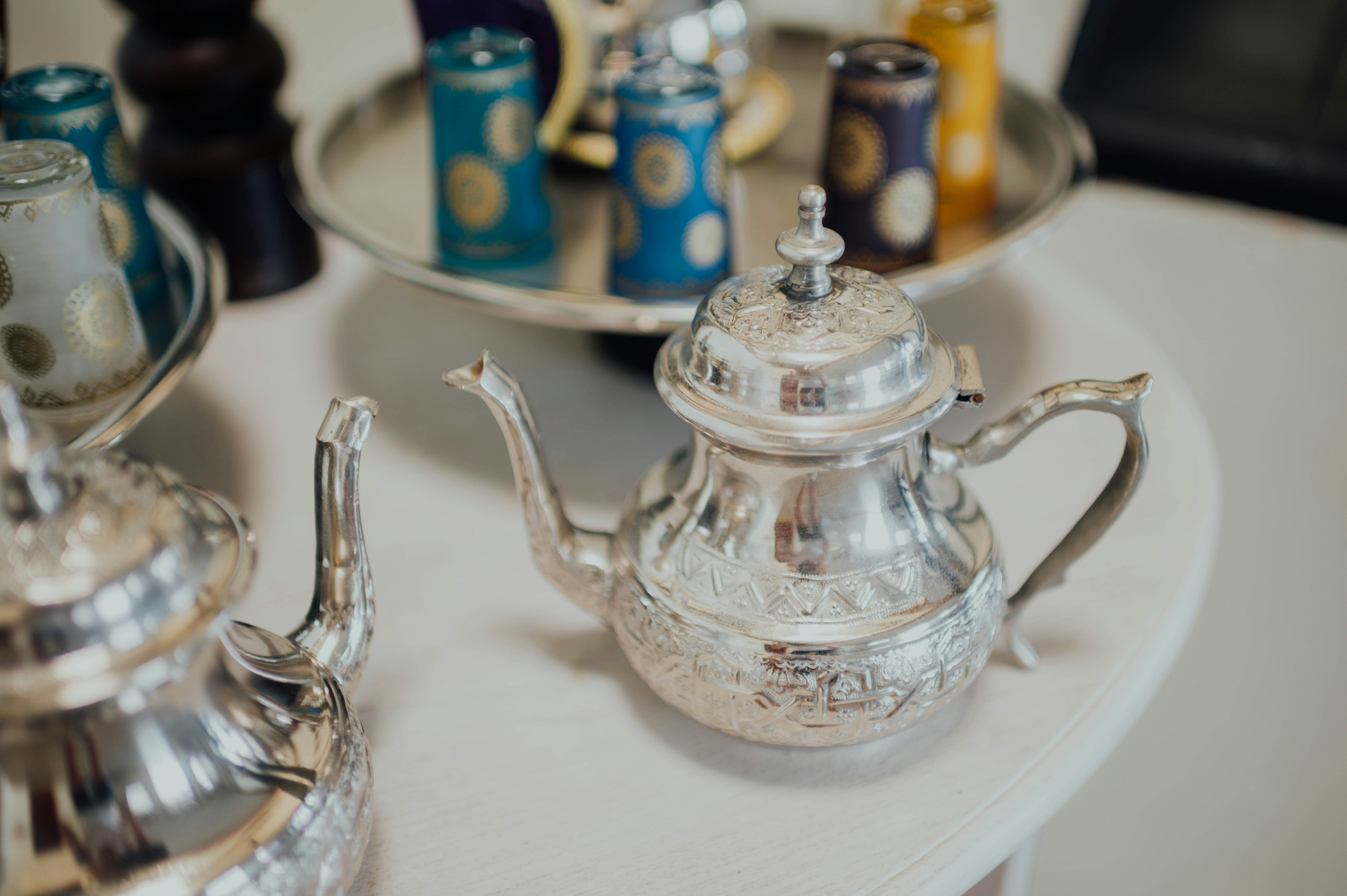 stainless steel teapot on clear glass tray