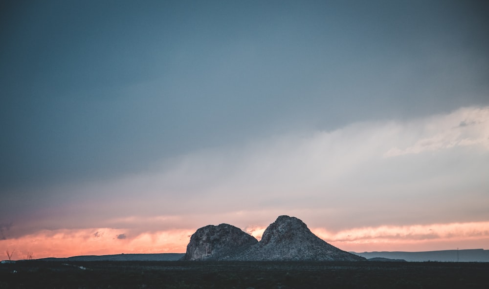 silhouette of mountain under cloudy sky during daytime