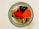 A glass jar is filled with colorful, heart-shaped candies and chocolates decorated with icing and sprinkles. The candies are vibrant with red and orange hues, complementing the white chocolate pieces.