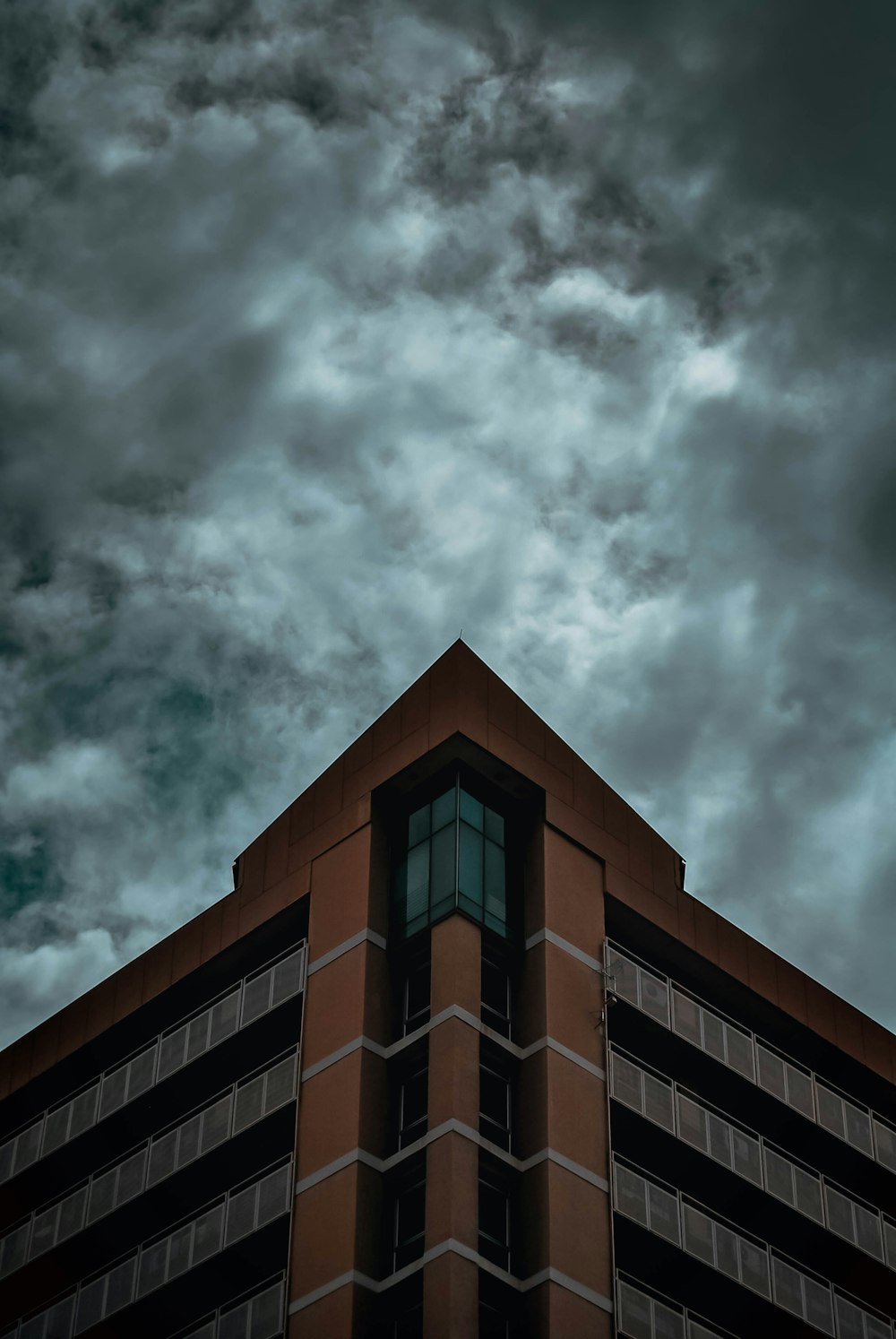 brown and black concrete building under gray clouds
