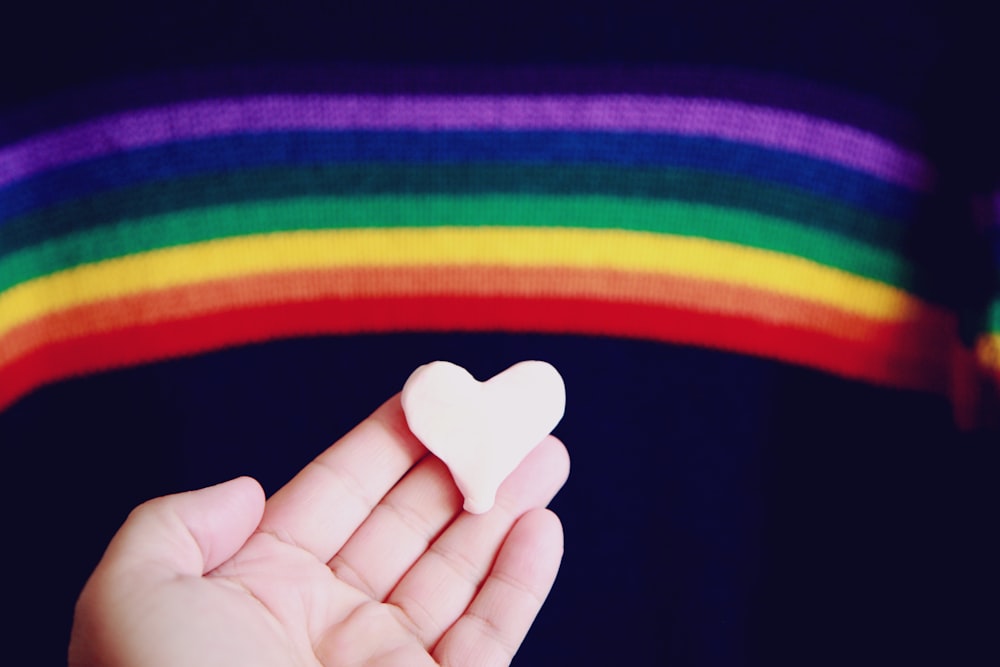 person holding white heart shaped ornament