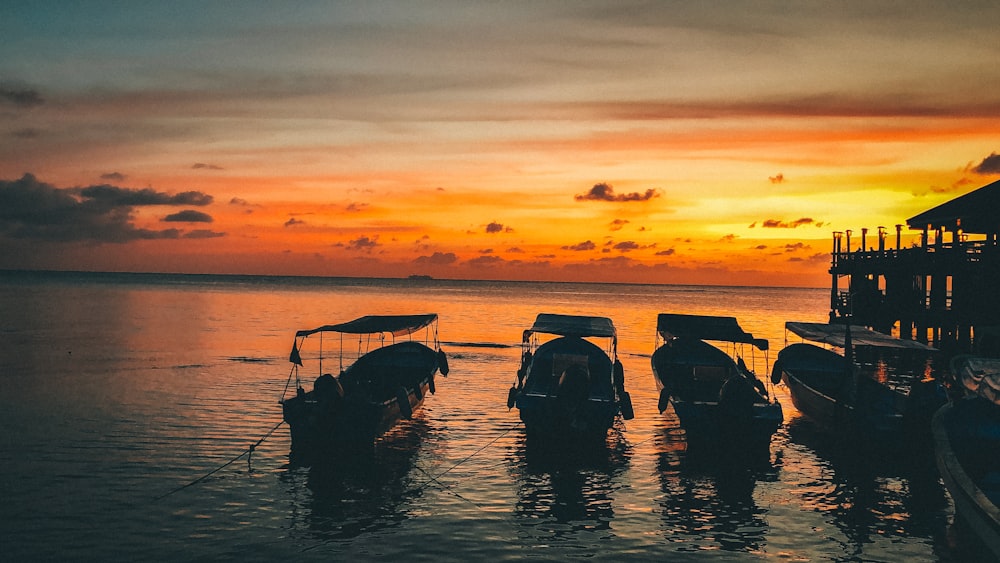 silhouette of people riding on boat during sunset