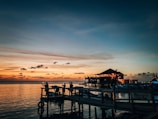 silhouette of people on dock during sunset