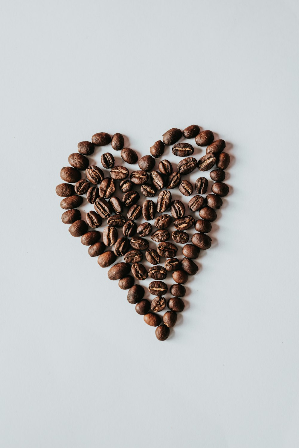 brown coffee beans on white surface