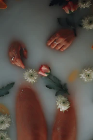 Close-up of hands receiving a gentle spa massage with rose petals.