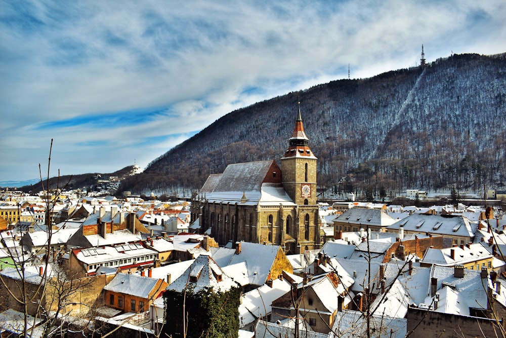 white and brown concrete building near mountain under white clouds during daytime