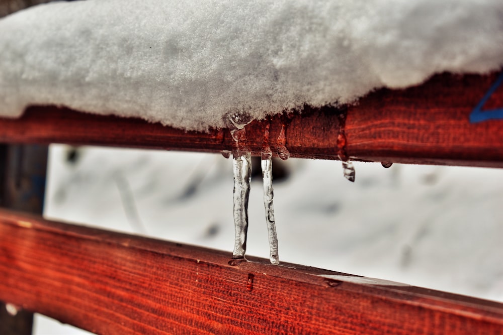 brown wooden fence with snow