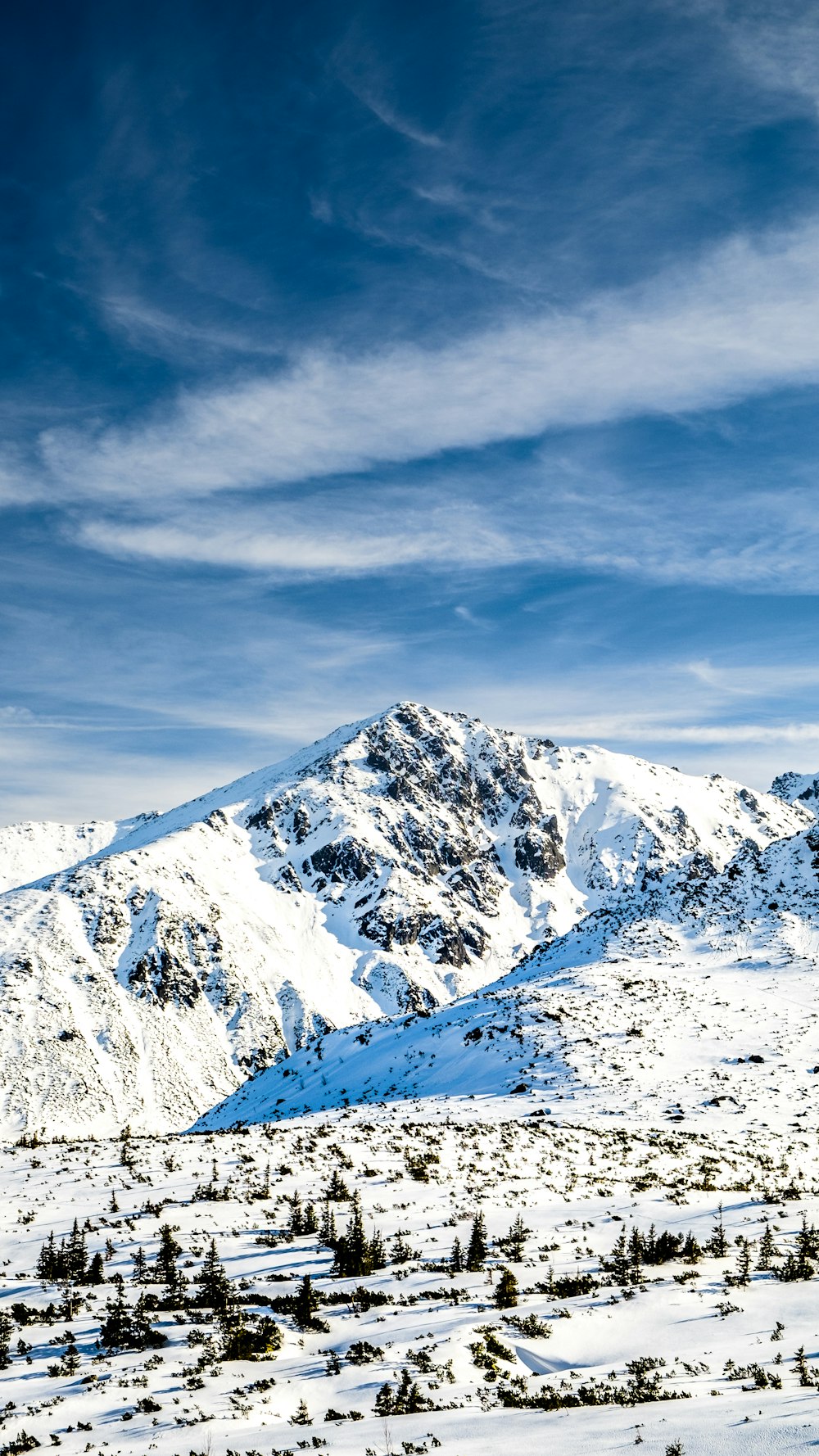 Schneebedeckter Berg tagsüber unter bewölktem Himmel