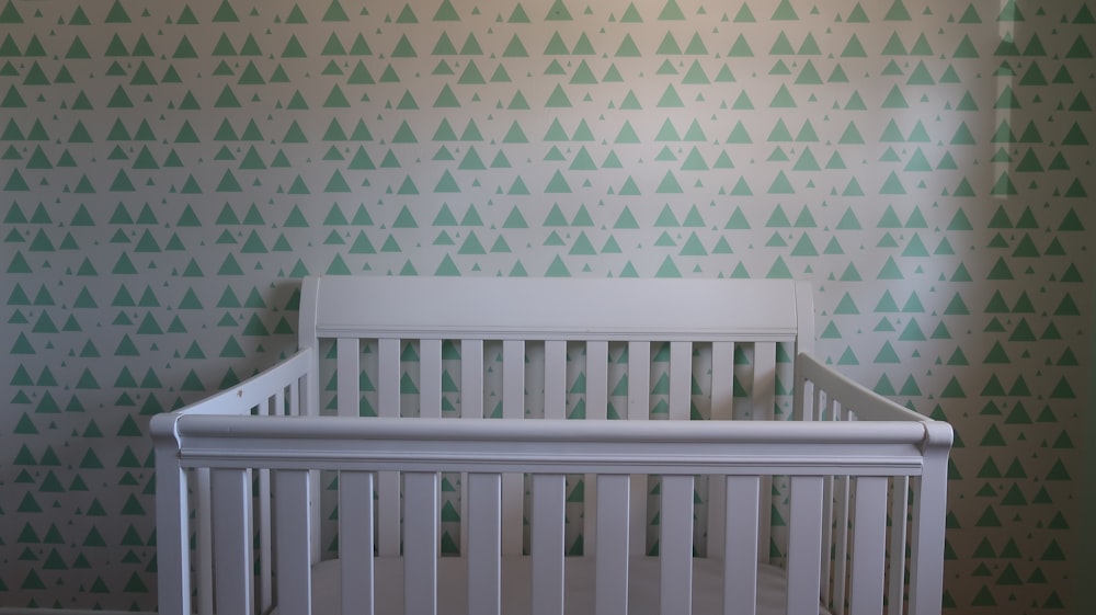 white wooden crib with white and blue polka dot wall