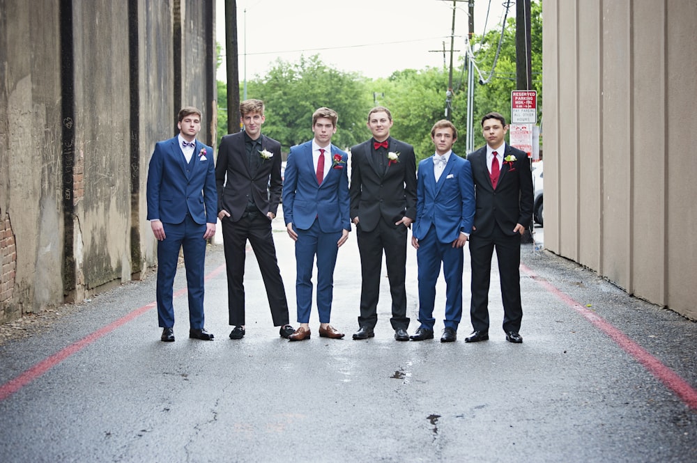 灰色のコンクリートの床に立つ青いスーツを着た男性のグループ