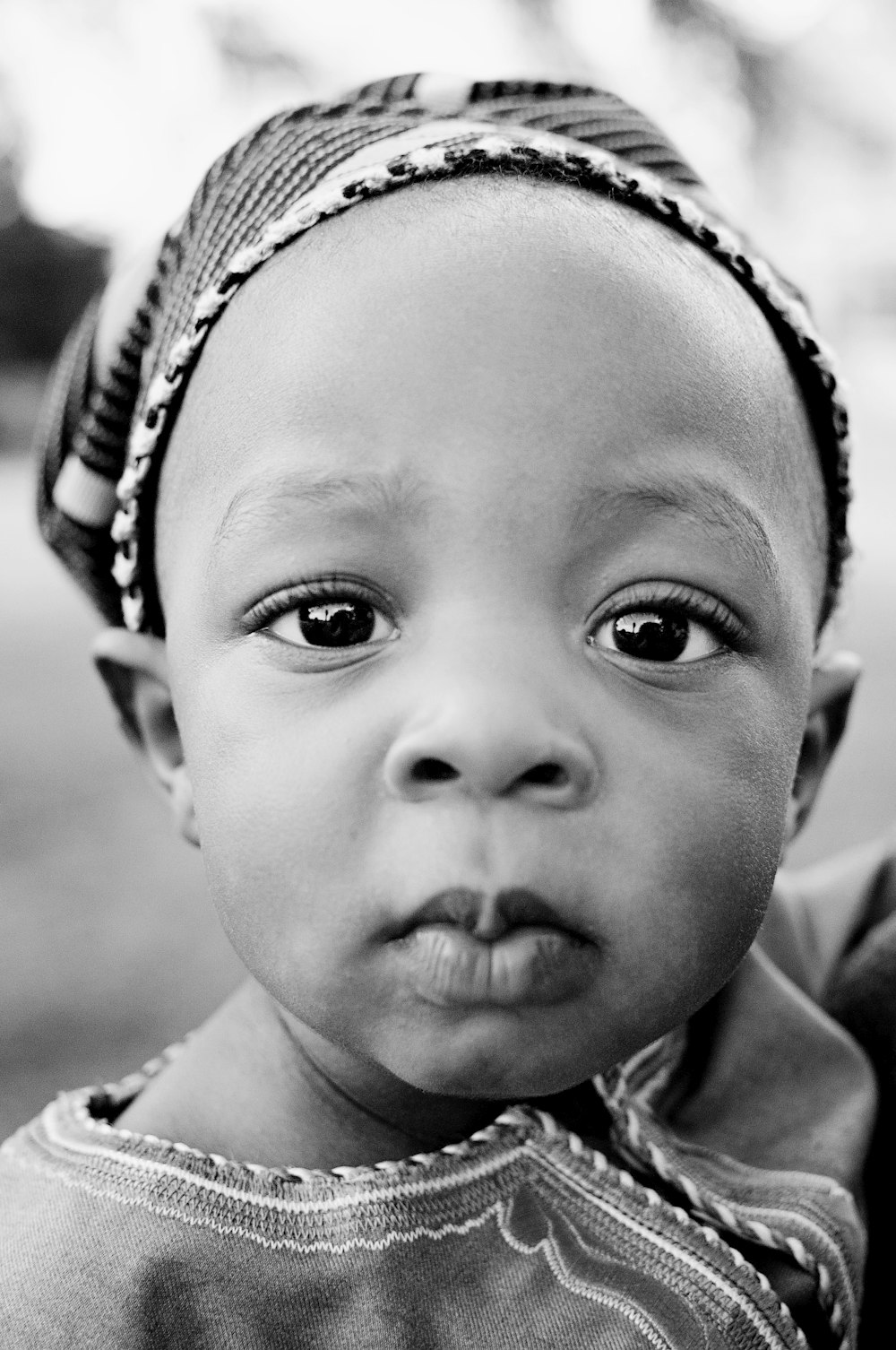 grayscale photo of baby wearing white and black floral headband