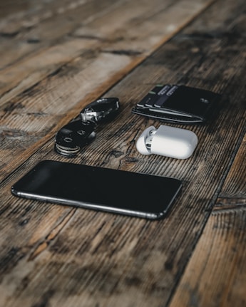 black and silver dslr camera beside black samsung android smartphone on brown wooden table