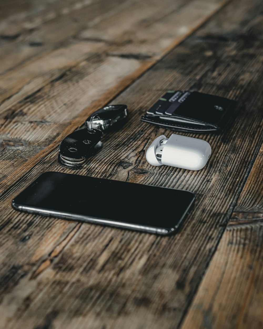 black and silver dslr camera beside black samsung android smartphone on brown wooden table